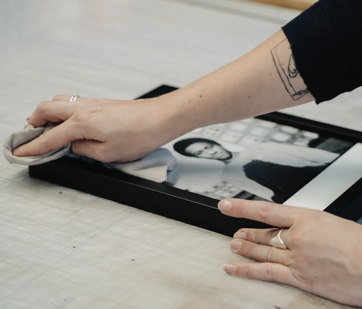 Polishing a handmade black frame in our framing workshop
