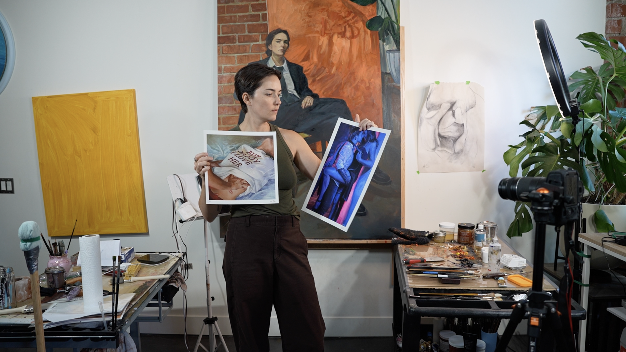 Halie Torris holding two of her prints in the studio