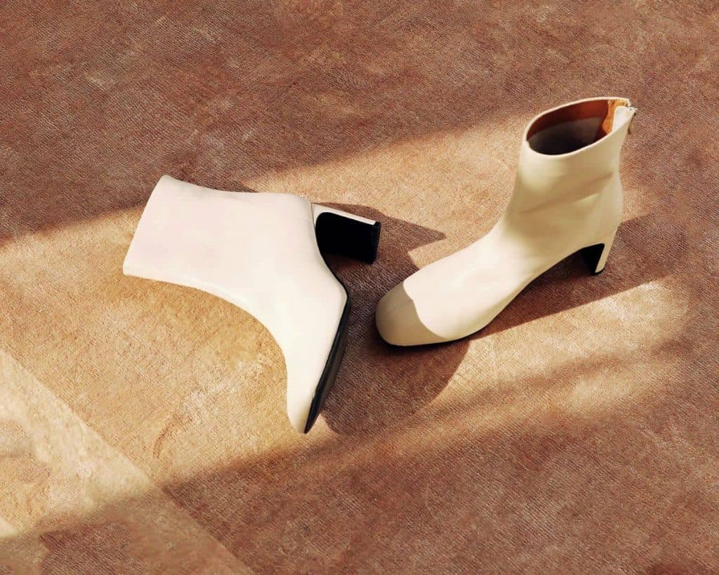 Heeled boots in a sunny spot on a brown carpeted floor by London-based product photographer Cormac Banks